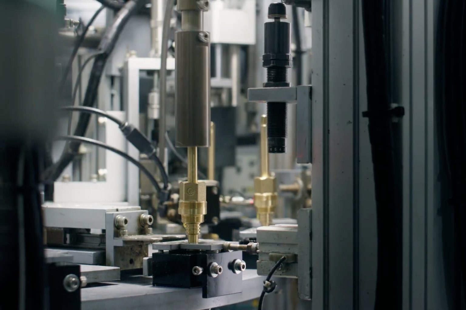 CNC machine manufacturing brass faucet cartridge on precision assembly line