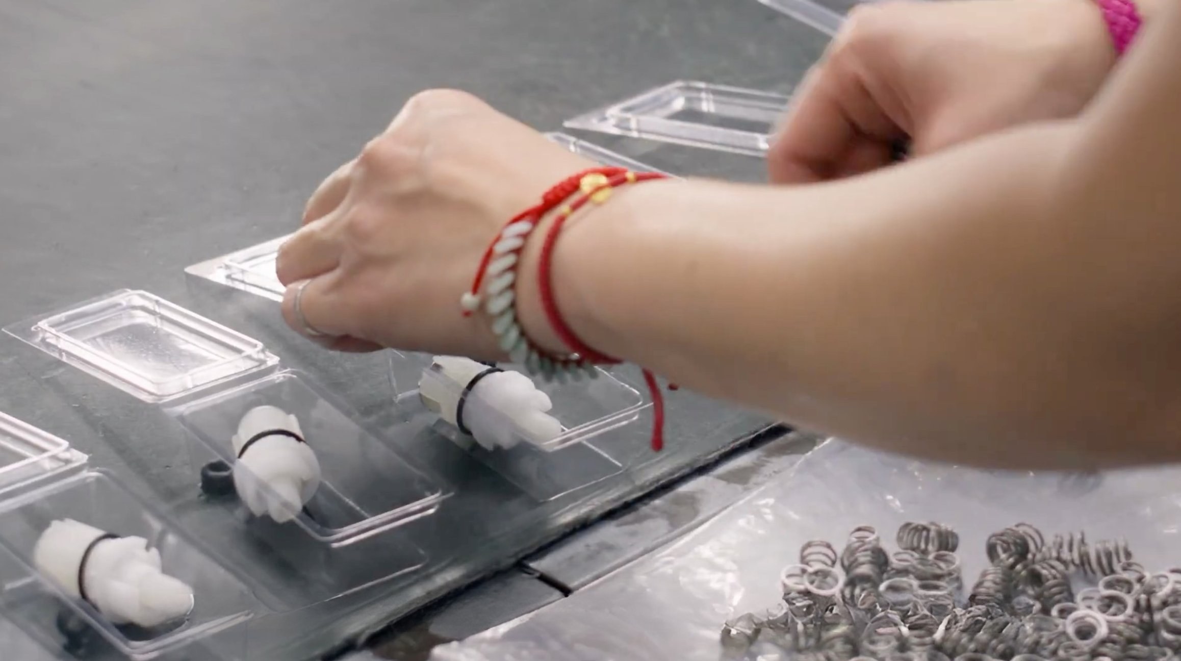 Factory worker packing cartridges into clamshell packaging